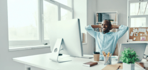 An African American man smiling at a screen, redefining success with mental health OT for work-life balance in Portland, OR.