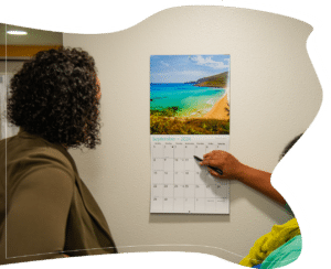 The therapist explains a calendar schedule while another woman listens, planning supportive steps and routines for progress