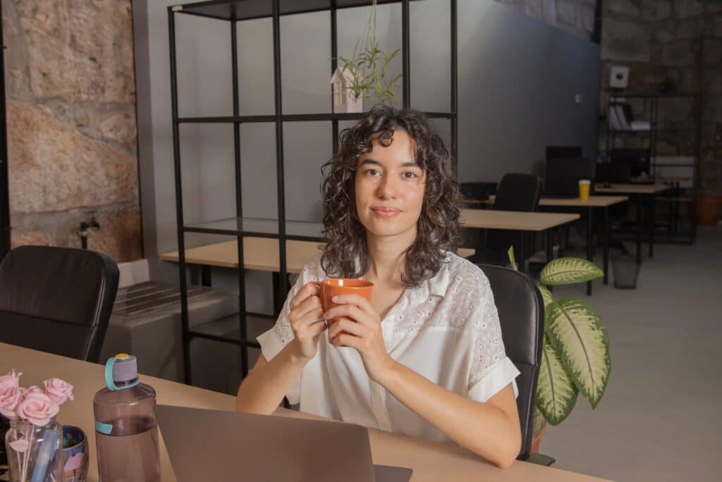 Burnout recovery Portland: A professional sitting at a desk holding a warm mug during a quiet break, symbolizing mindful rest, stress relief, and work-life balance support.