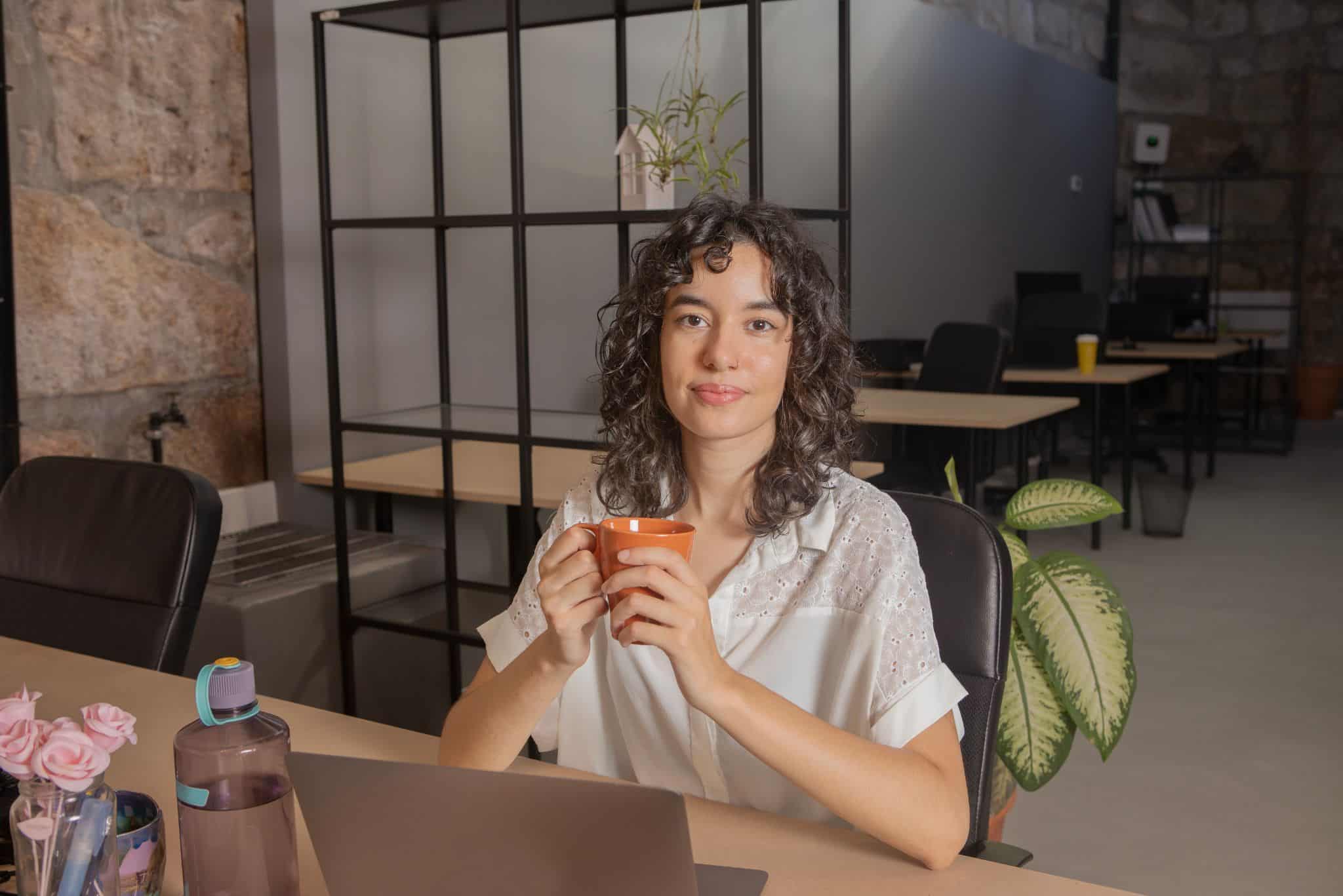 Burnout recovery Portland: A professional sitting at a desk holding a warm mug during a quiet break, symbolizing mindful rest, stress relief, and work-life balance support.