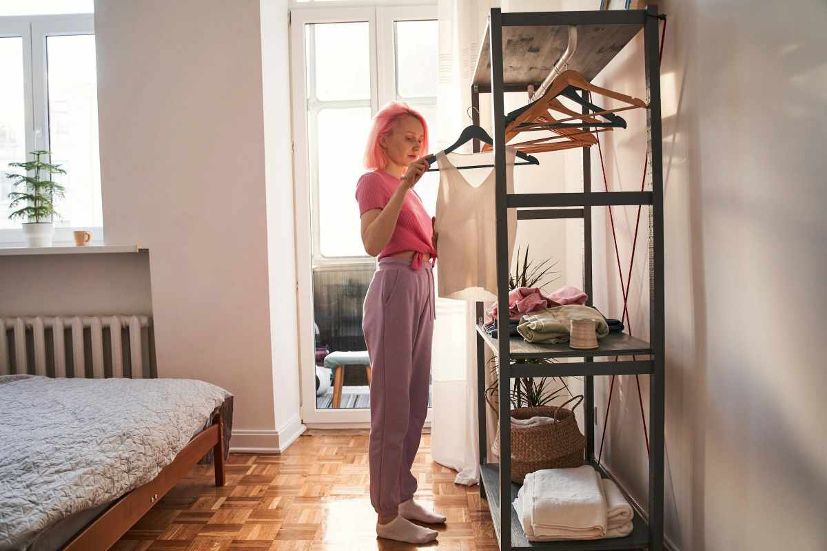 Person selecting clothes from a wardrobe, representing occupational therapy support for self-care and daily living skills.