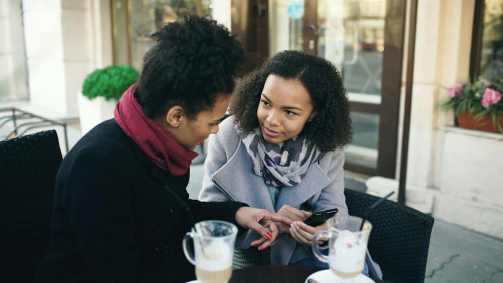 Adults connecting at a café, representing a support network for neurodivergent and queer adults