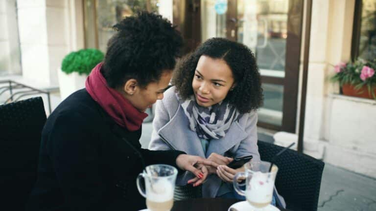 Adults connecting at a café, representing a support network for neurodivergent and queer adults