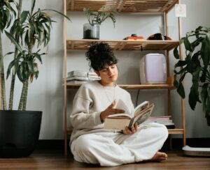 Woman reading a book in a minimalist space, calm environment supporting focus and quiet exploration