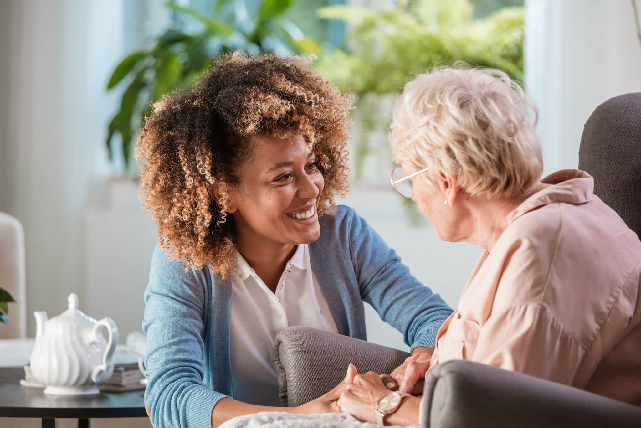 Occupational therapist supporting an older adult during a home visit focused on daily functioning and chronic illness care