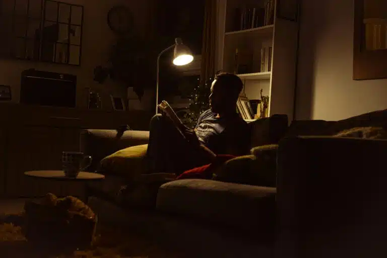 Adult sensory processing overload—person sitting in a quiet space recovering with reduced light and noise
