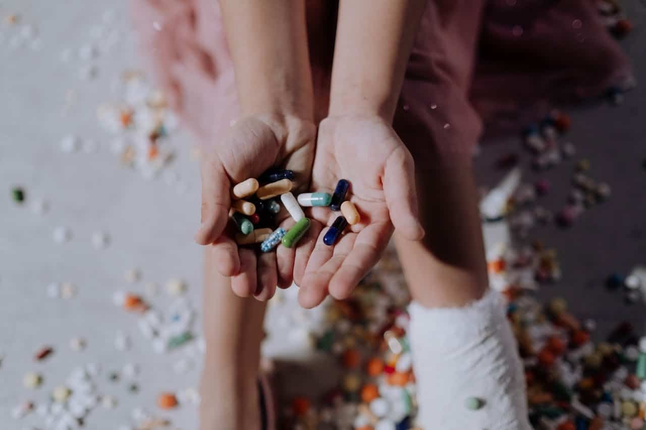 Person holding multiple medications symbolizing anxiety and depression in chronic illness