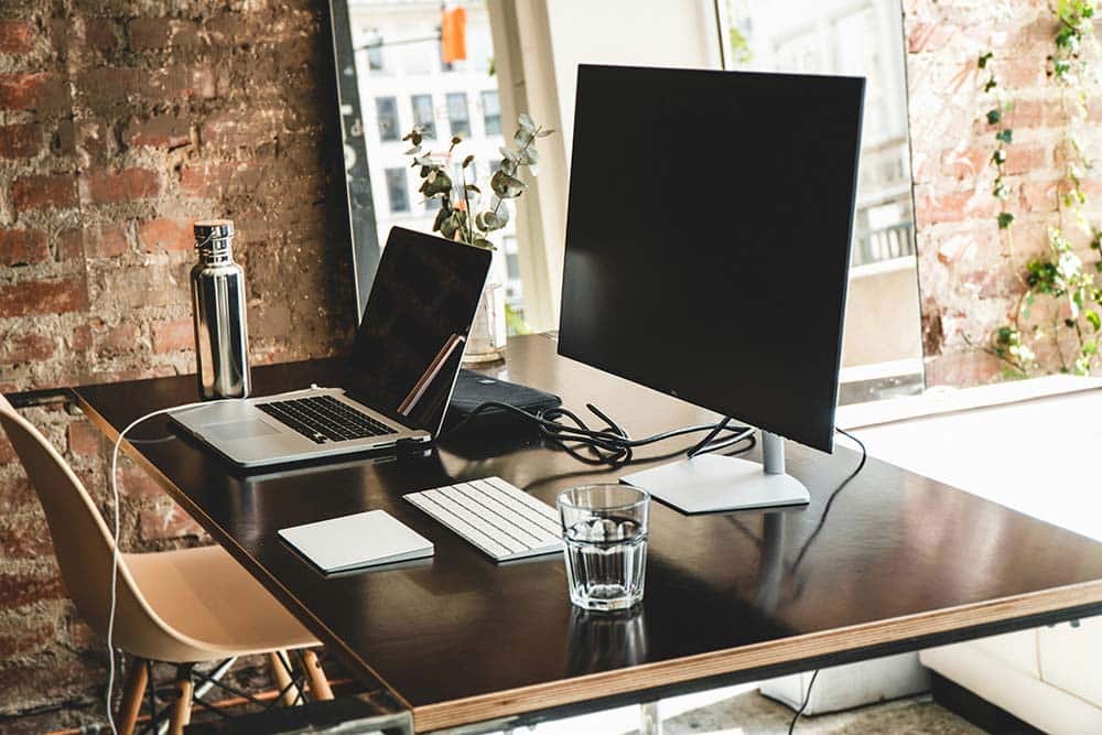 Black flat screen computer monitor on brown wooden desk
