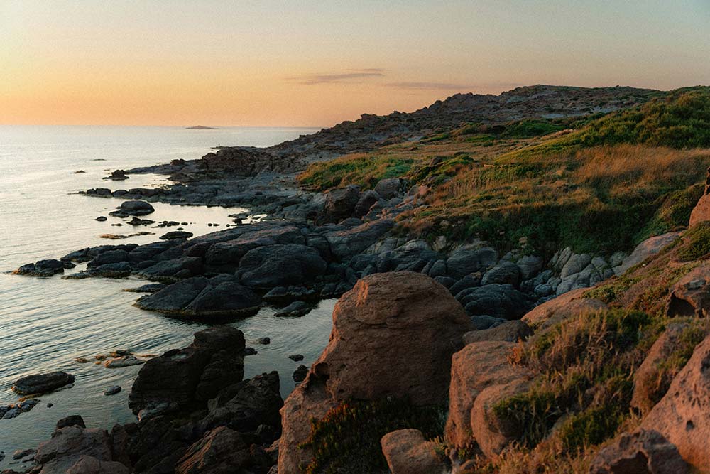 Rocky coastline and calm ocean at sunset