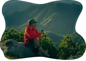man-sitting-on-rock-mountain-view