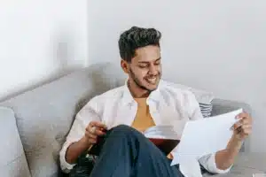A man enjoying a quiet, cozy afternoon reading a book while lounging comfortably on his living room couch.